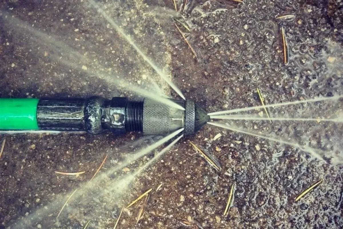 A water spray gun spraying water on the ground.